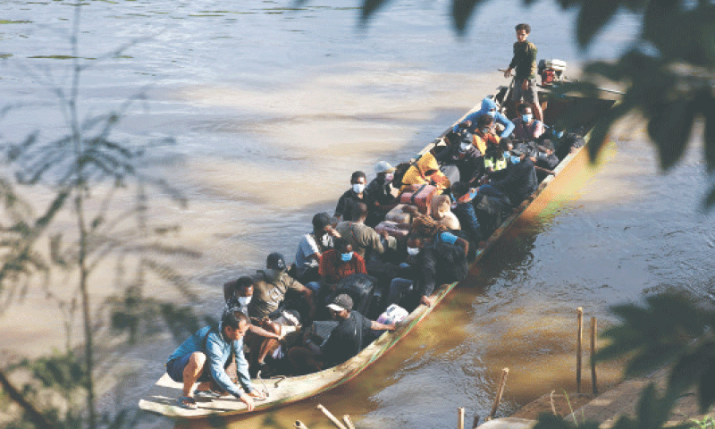 PEOPLE from various countries who were working at a scam centre in Myanmar, travel in a boat across the Moei River to cross over into Thailand.—AFP PEOPLE from various countries who were working at a scam centre in Myanmar, travel in a boat across the Moei River to cross over into Thailand.—AFP
