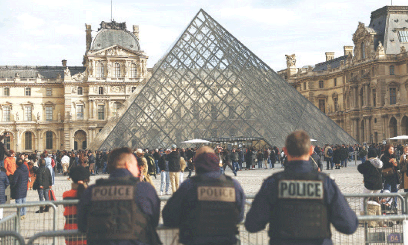 Police officers stand guard near the Louvre museum after French authorities arrested suspects involved in a jewel heist.—Reuters Police officers stand guard near the Louvre museum after French authorities arrested suspects involved in a jewel heist.—Reuters