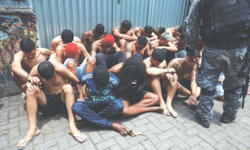 RIO DE JANEIRO: Suspected drug dealers sit on the ground after they were detained by Brazil&rsquo;s military police during an operation against drug traffickers.&mdash;Reuters