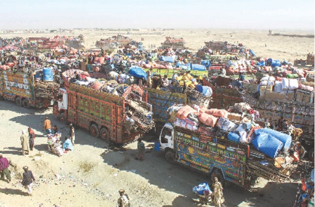 AFGHAN refugees, along with their belongings, await deportation near the border in Chaman.—AFP