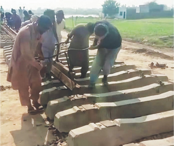 TOBA TEK SINGH: Work of re-laying of track is underway near Darkhana in Khanewal district. — Dawn