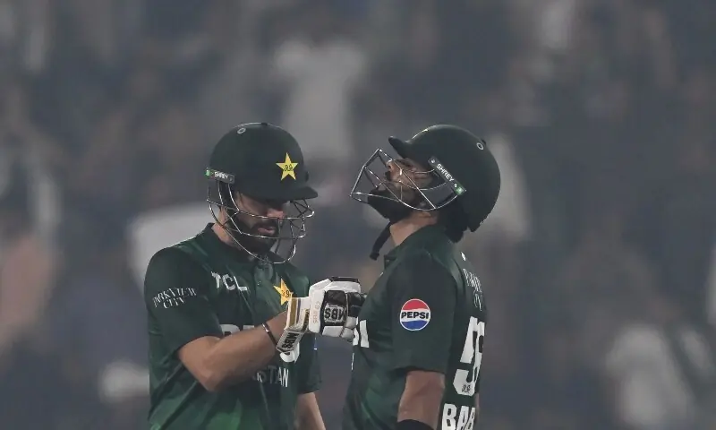 Babar Azam (R) celebrates his half century with captain Salman Agha (L) during the third and final Twenty20 international cricket match between Pakistan and South Africa at the Gaddafi Stadium in Lahore on November 1. &mdash; AFP