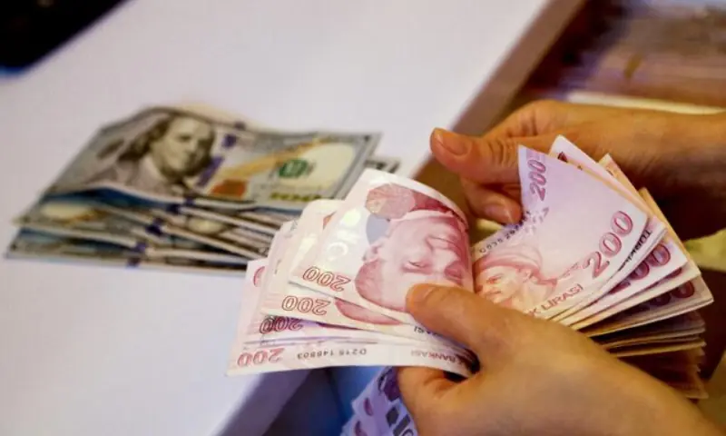 A money changer counts Turkish lira banknotes at a currency exchange office in Ankara, Turkey, on September 27, 2021. &mdash; Reuters/File