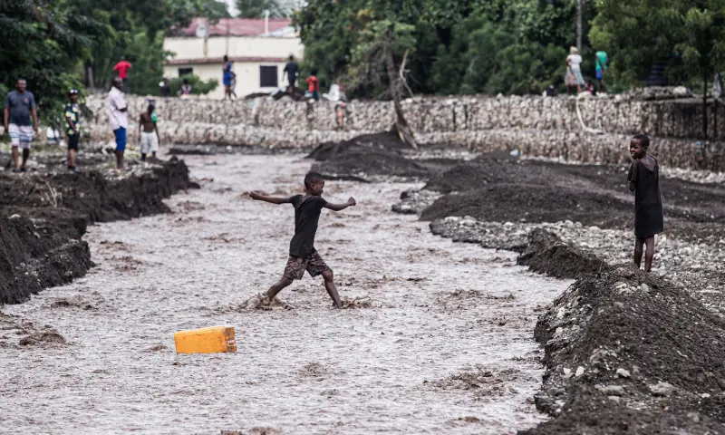 Children walk through a flooded street in the aftermath of Hurricane Melissa, in Petit-Goave, about 68 km (42 miles) southwest of Port-au-Prince, on October 31, 2025. &mdash; AFP