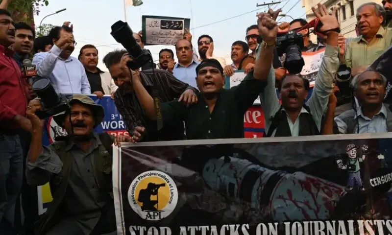 Photojournalists hold their cameras and shout slogans during a demonstration to mark World Press Freedom Day in Lahore. &mdash; AFP