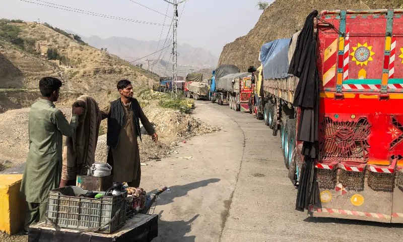 In this file photo, a tea vendor stands near the stalled vehicles near the closed Pakistan-Afghanistan border town of Torkham on October 19, 2025. &mdash; AFP