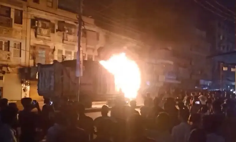 Flames rise from a dumper truck that was torched by enraged people after it hit a couple on a motorcycle, killing the man, in Karachi&rsquo;s Korangi on early hours of Nov 4, 2025. &mdash; DawnNewsTV