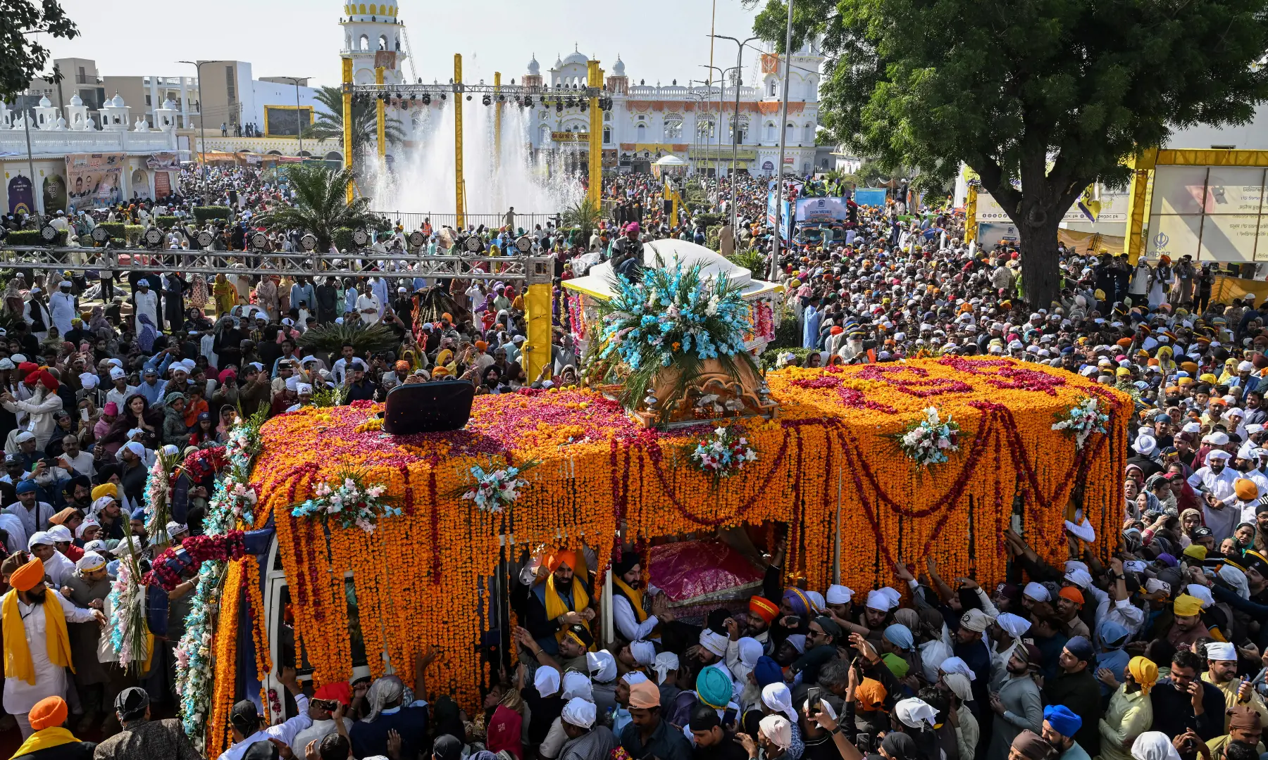 Sikh devotees gather around a bus carrying the Guru Granth Sahib, the Sikh holy book, during a religious procession to mark the birth anniversary of Guru Nanak Dev, the founder of Sikhism, at Nankana Sahib in Punjab. — AFP