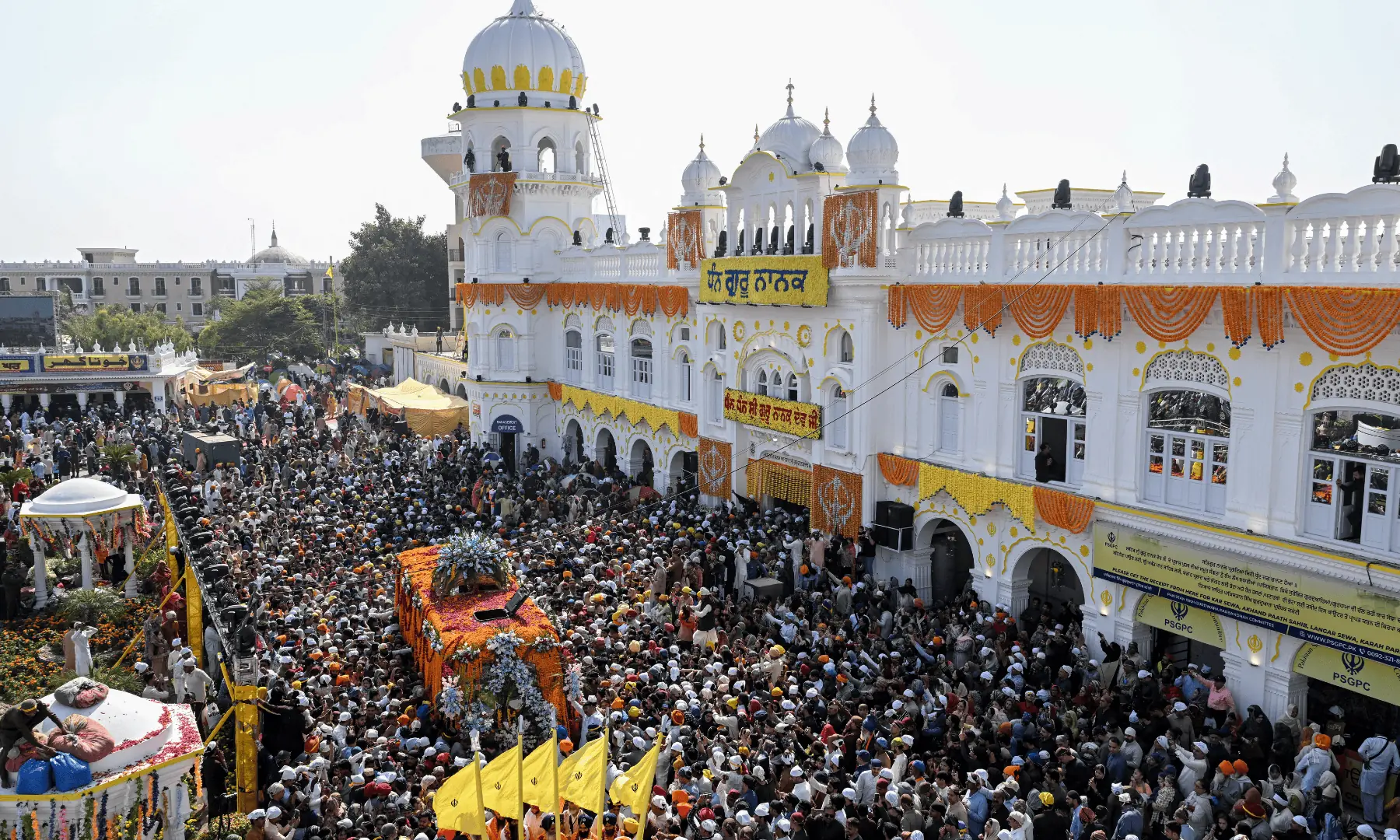 Sikh devotees gather around a bus carrying the Guru Granth Sahib, the Sikh holy book, during a religious procession to mark the birth anniversary of Guru Nanak Dev, the founder of Sikhism, at Nankana Sahib in Punjab. — AFP