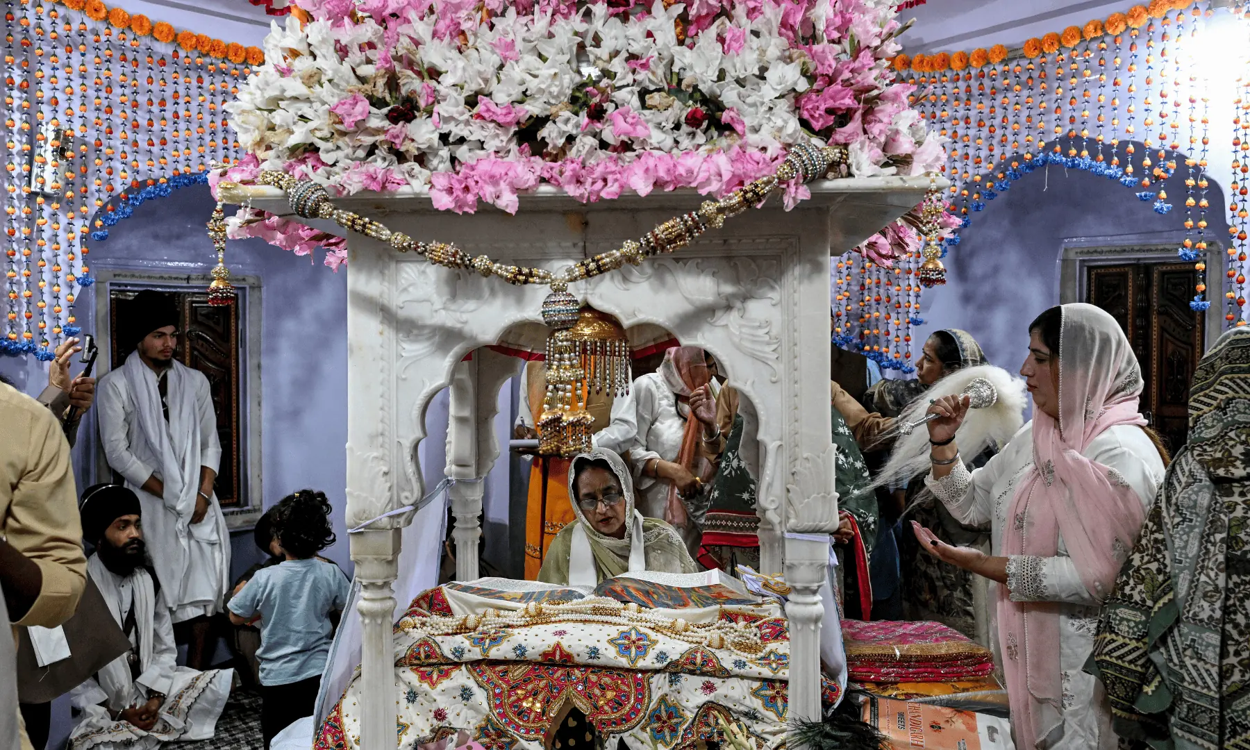 A Granthi, or ceremonial reader, recites the Guru Granth Sahib (Sikh holy book) as devotees offer prayers on the occasion of the birth anniversary of Guru Nanak Dev, the founder of Sikhism, at Nankana Sahib in Punjab. — AFP