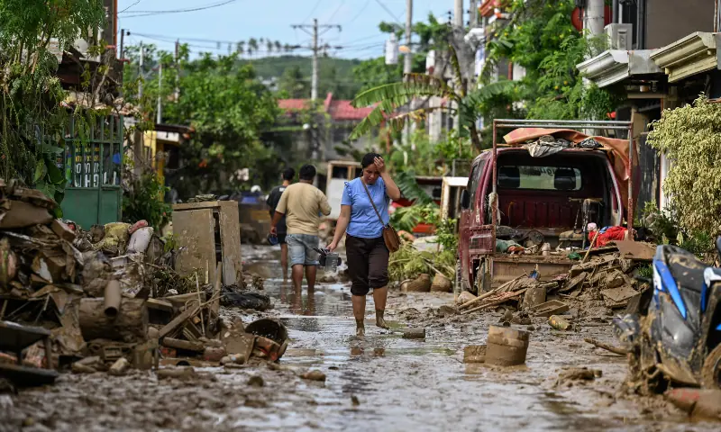 A woman walks along a mud covered street in the aftermath of Typhoon Kalmaegi in Liloan, in the province of Cebu on November 6, 2025. &mdash; AFP