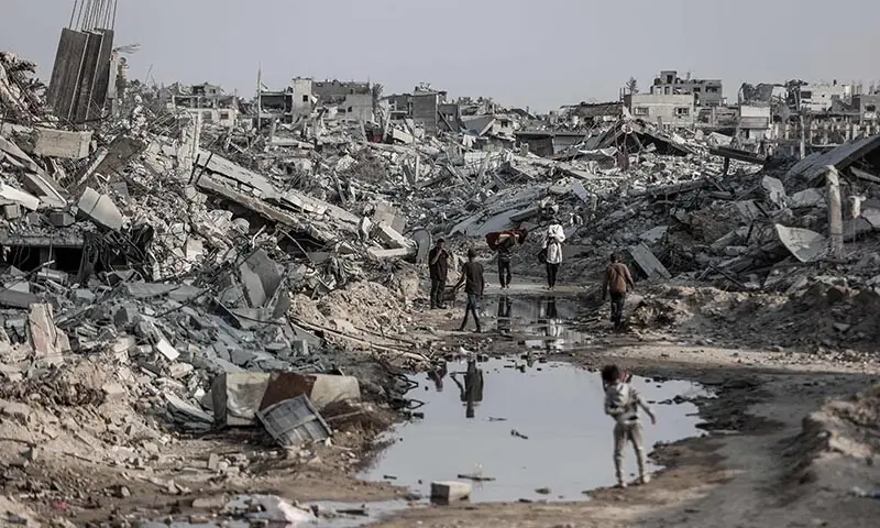 Palestinians make their way through the rubble of destroyed buildings in Jabalia, in the northern Gaza Strip, on November 7, 2025. The United Nations said on November 4 it had distributed food parcels to one million people in Gaza since the ceasefire, but warned it was still in a race to save lives. AFP