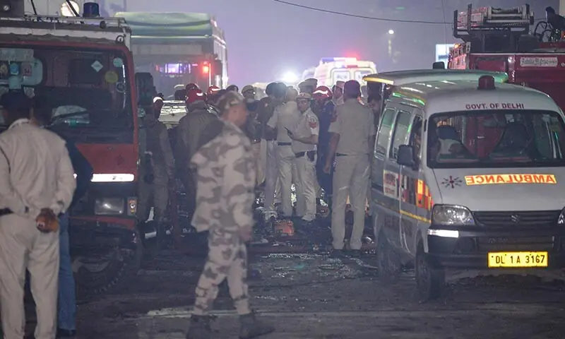 Security personnel gather beside an ambulance at the site of an explosion near the Red Fort in the old quarters of New Delhi, India on November 10. — AFP