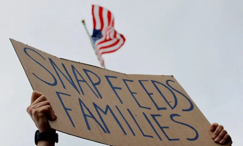 A man holds a sign reading &ldquo;SNAP Feeds Families,&rdquo; as food aid benefits will be suspended starting November 1. &mdash; Reuters