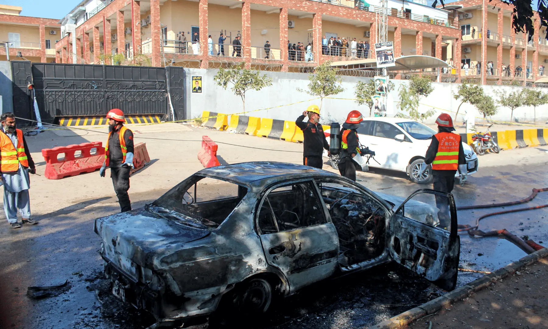 Firefighters douse a car at the suicide blast site in Islamabad. &mdash; AFP
