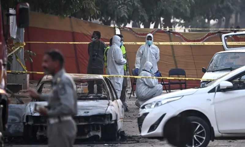 Forensic experts examine a car after a suicide blast outside the district courts in Islamabad.—AFP Forensic experts examine a car after a suicide blast outside the district courts in Islamabad.—AFP
