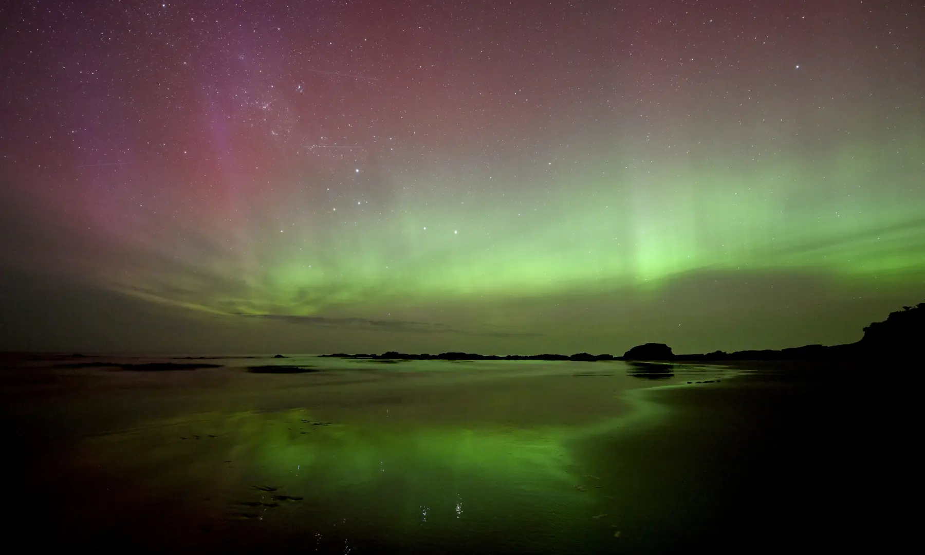 The Aurora Australis, also known as the Southern Lights, glows on the horizon over the waters of Brighton Beach in Dunedin on November 13. — AFP