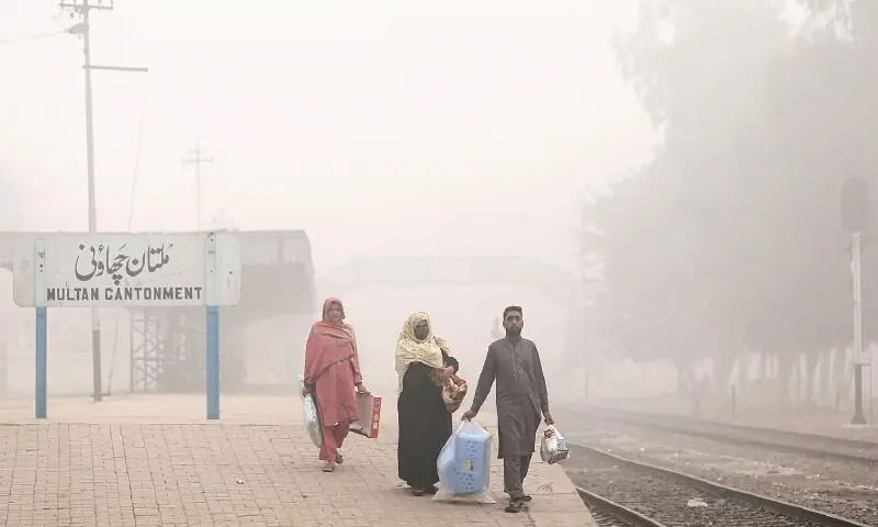 Passengers wait for the train at the Multan Cantonment station, engulfed by thick smog.—AFP Passengers wait for the train at the Multan Cantonment station, engulfed by thick smog.—AFP