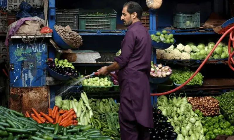 In this file photo, a vendor waters the vegetables at a stall in Islamabad. &mdash; Reuters/File