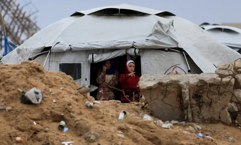A Palestinian girl gestures from a tent on a rainy day, during a ceasefire between Israel and Hamas, in Gaza City, on November 14. &mdash; Reuters/File