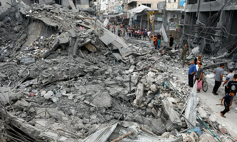 Palestinians inspect the damage in the aftermath of Israeli strikes, in Khan Younis, southern Gaza Strip on October 10, 2023.&mdash;Reuters/Ibraheem Abu Mustafa