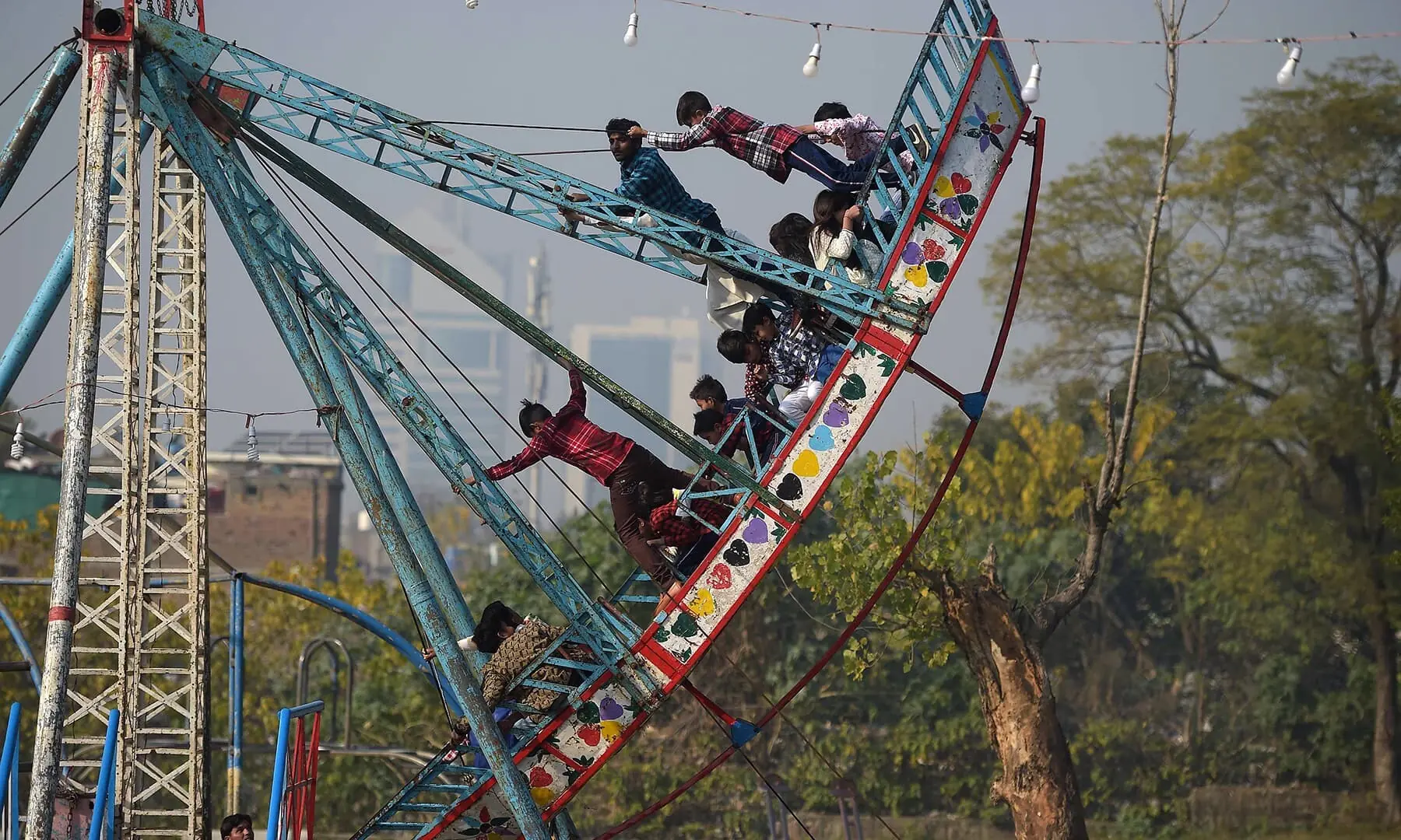 Image shows children ride on a swing.   &mdash; AFP/ File