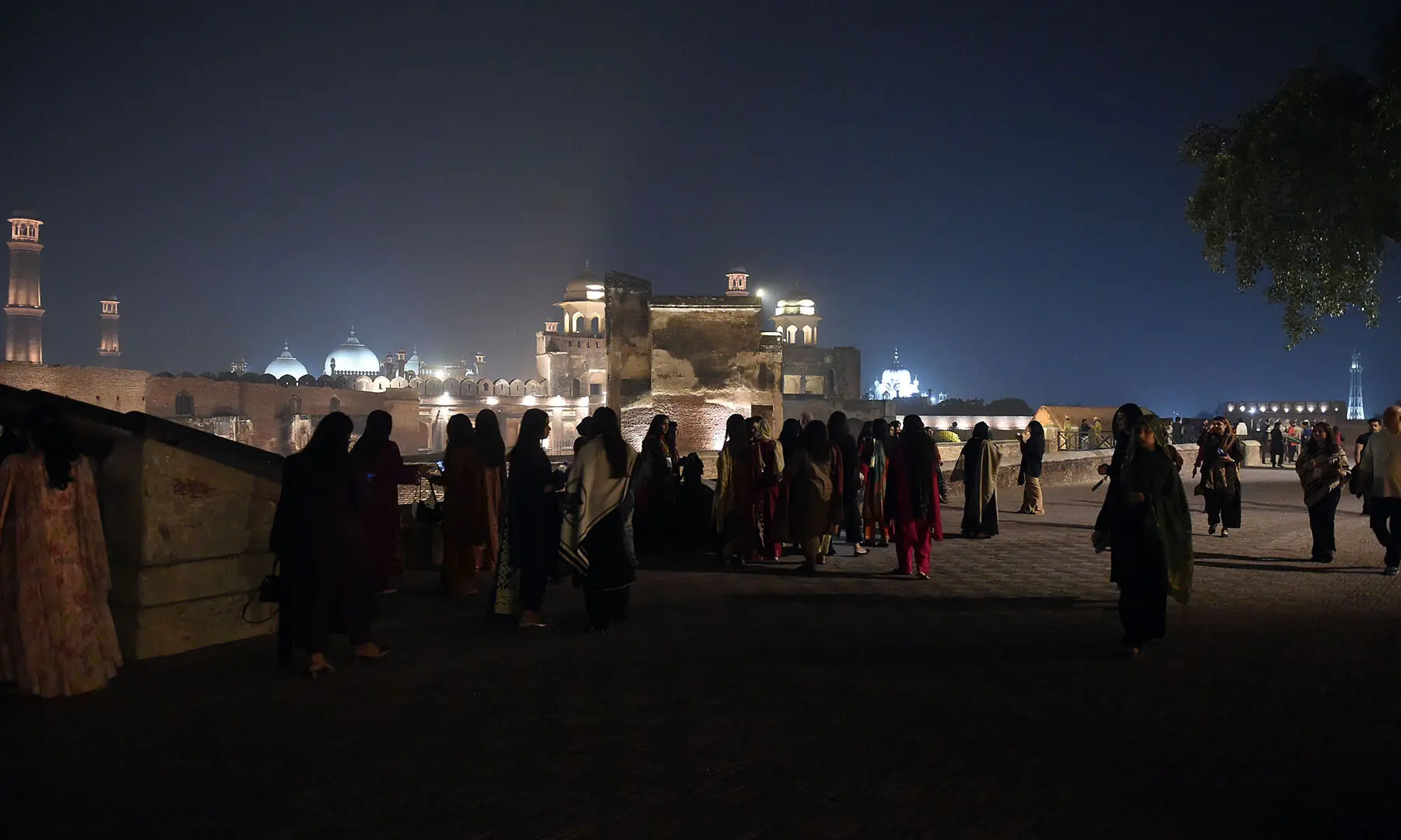 Visitors take in a view from Lahore Fort, with Badshahi Masjid and Minar-i-Pakistan visible in the background, during a night tour on November 15. —White Star/Murtaza Ali