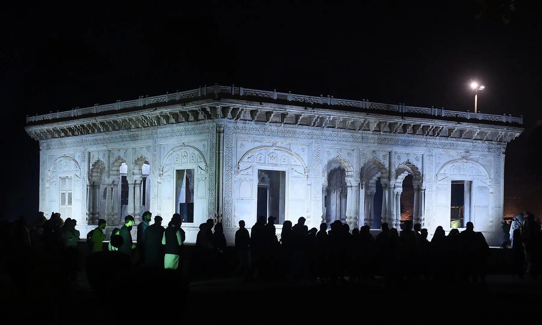 Visitors view the Hazuri Bagh pavilion during a night tour of the walled city of Lahore on November 15. —White Star/Murtaza Ali