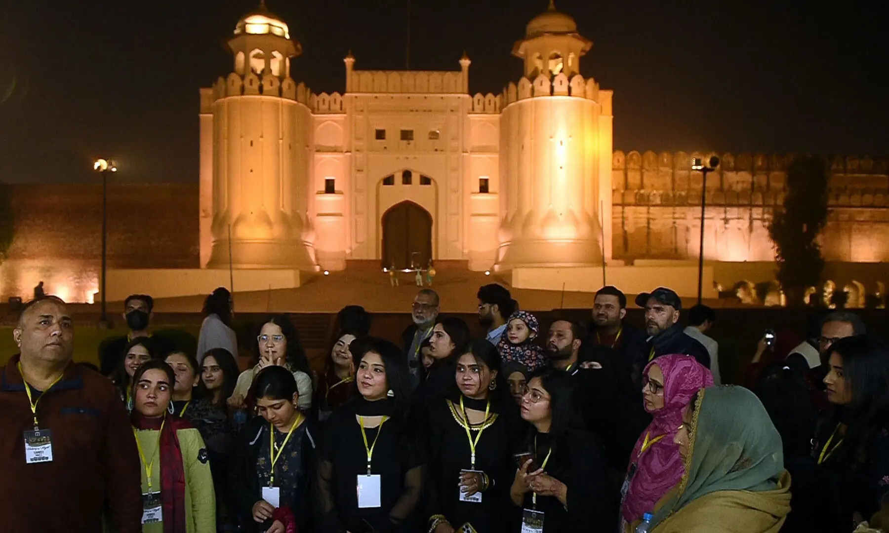 Visitors stand in front of the Alamgiri Gate during a night tour of the walled city of Lahore on November 15. —White Star/Murtaza Ali