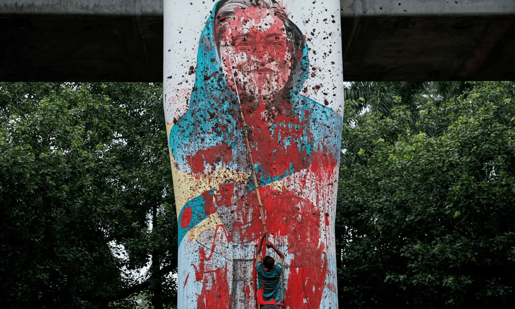 A protester vandalises a mural of Sheikh Hasina with paint, demanding her resignation at Teacher Student Center area of University of Dhaka in Dhaka, on August 3, 2024. — Reuters