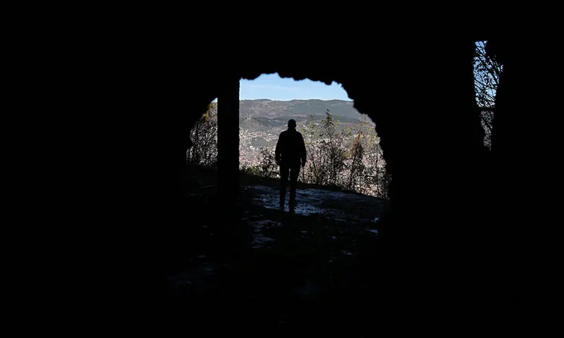 A Bosnian worker looks out at Sarajevo through a hole in a war-damaged building that once marked the front line during the 1992&ndash;95 Bosnian War, in Sarajevo, Bosnia and Herzegovina on November 13. &mdash; Reuters