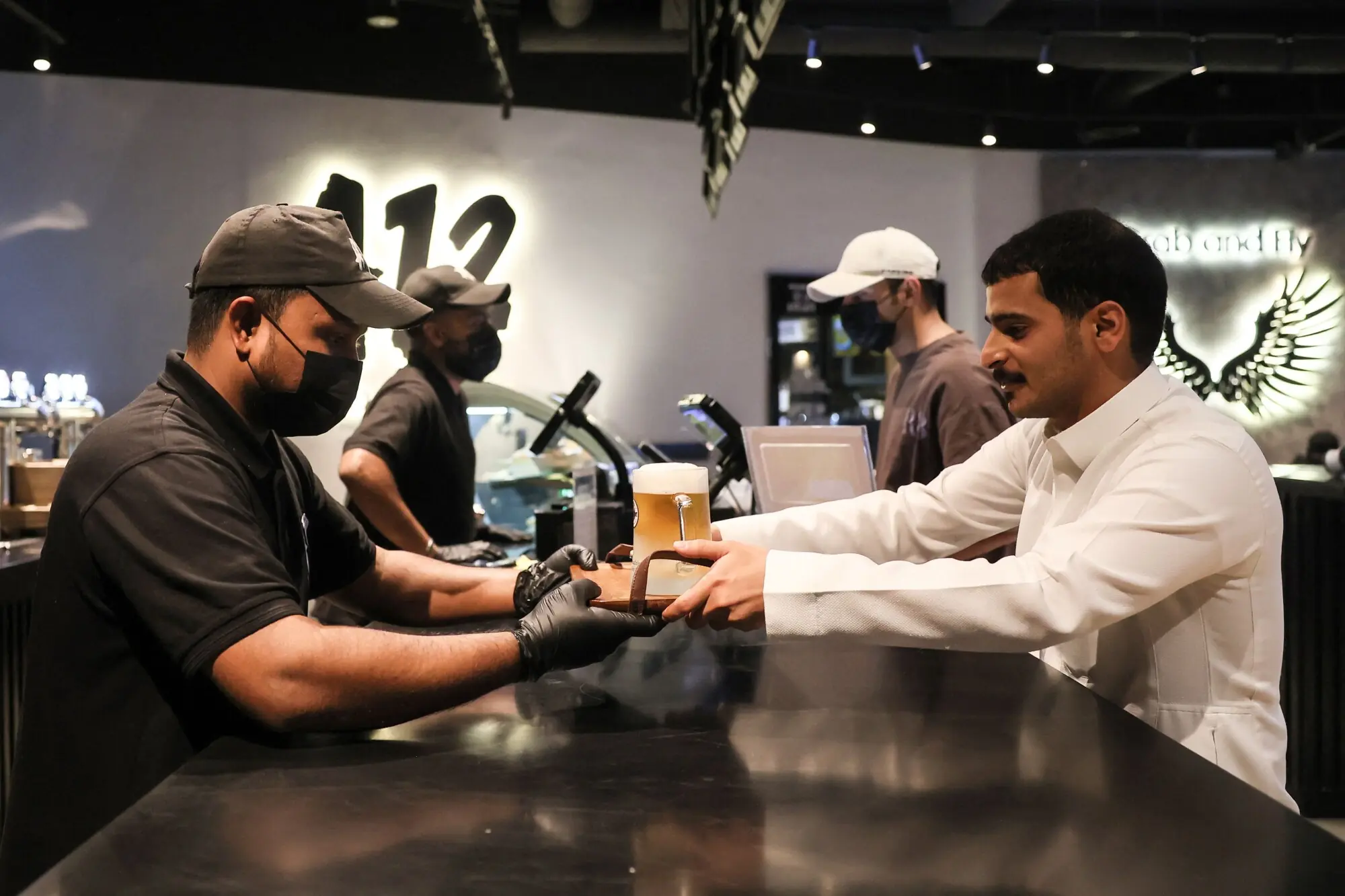  A young man receives a tray with a mug of beer at the A-12 cafe. Photo: AFP 