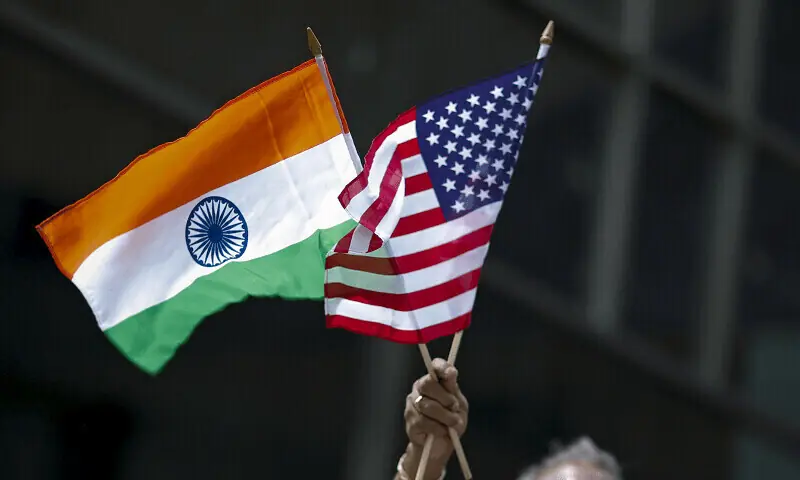 Image shows a person holding the Indian and the American flag. — AFP/File