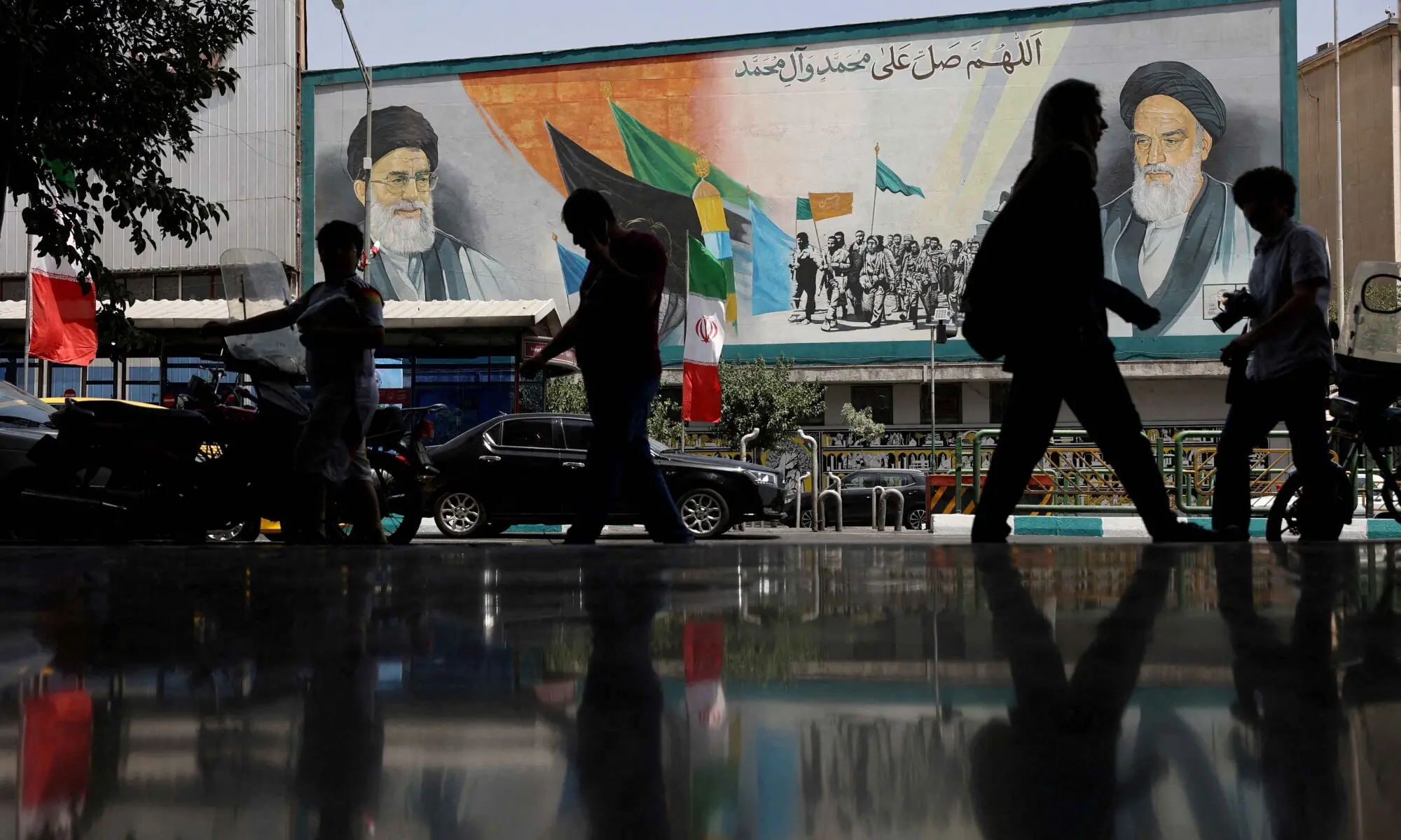 People walk past a mural of Iran&rsquo;s Supreme Leader Ayatollah Ali Khamenei on a street during the early hours of a ceasefire with Israel after 12 days of war, in Tehran, Iran, June 24, 2025. &mdash; Reuters