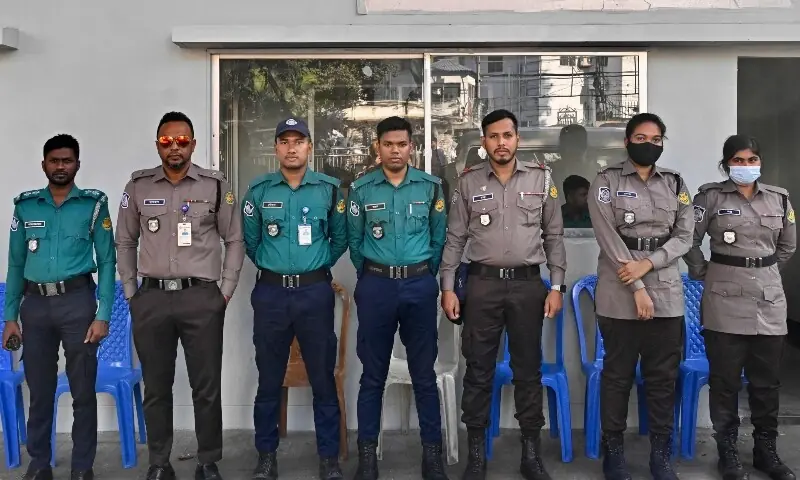 This photograph taken on November 18, 2025, shows Bangladesh Police personnel wearing the earlier (turquoise-and-blue) and the newly introduced (iron-grey and chocolate-brown) uniforms as they stand guard outside a police box in Dhaka. &mdash;AFP