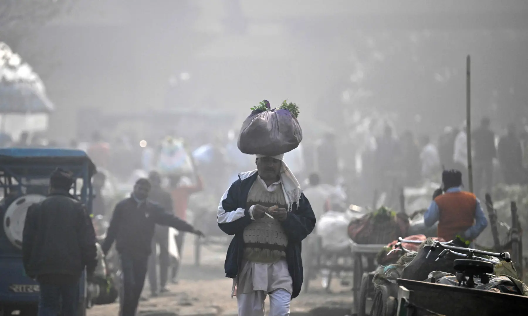 A man visits a market on a smoggy winter morning in New Delhi on November 21. &mdash; AFP