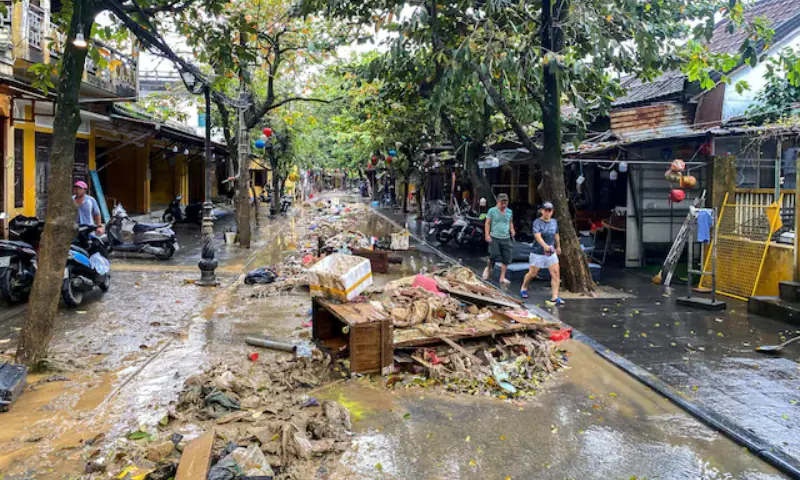 People walk past debris following floods in central Vietnam that have killed several people, in Hoi An, Vietnam, on November 1, 2025. &mdash; Reuters
