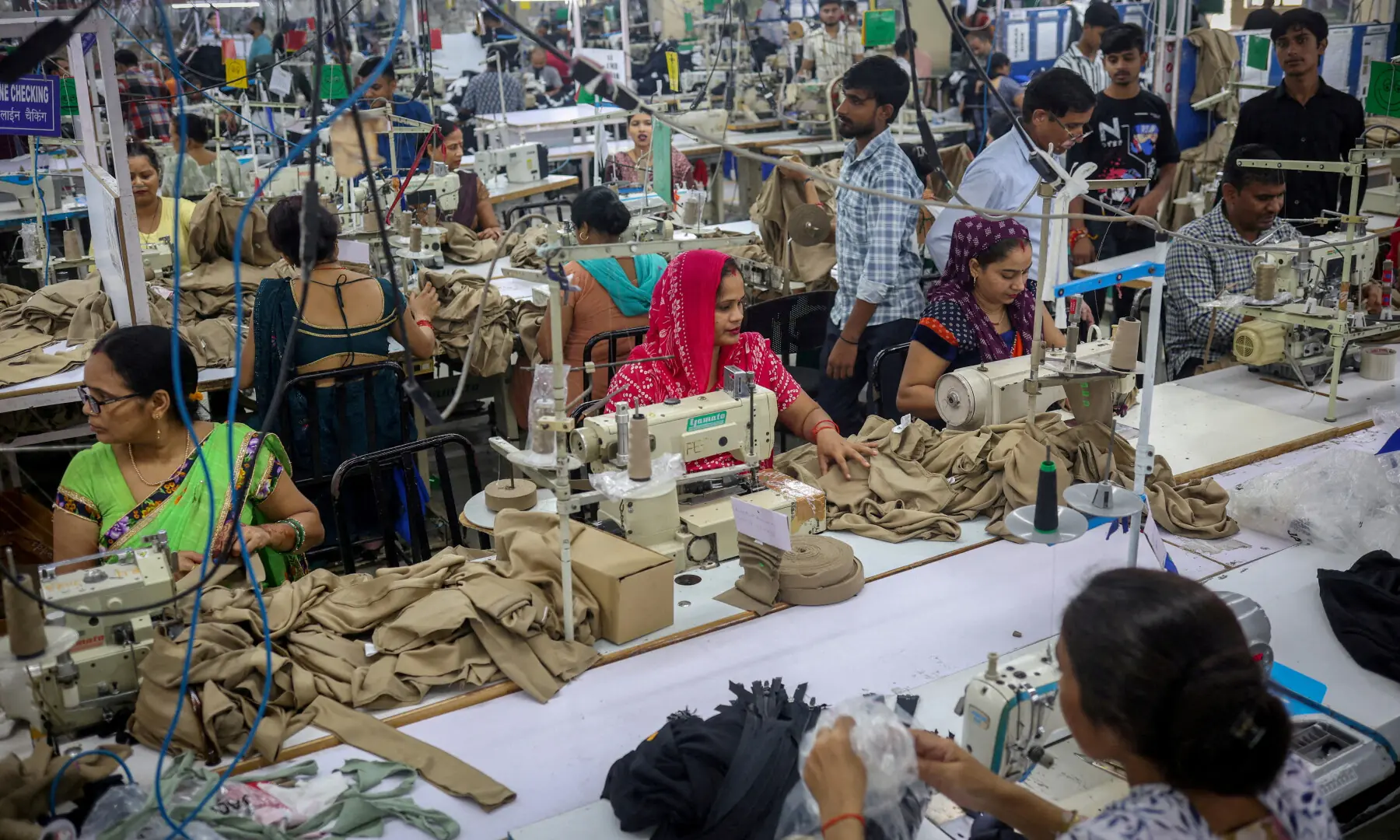 Workers stitch dresses at a garment manufacturing unit in Noida, India, on Aug 27, 2025. &mdash; Reuters/File