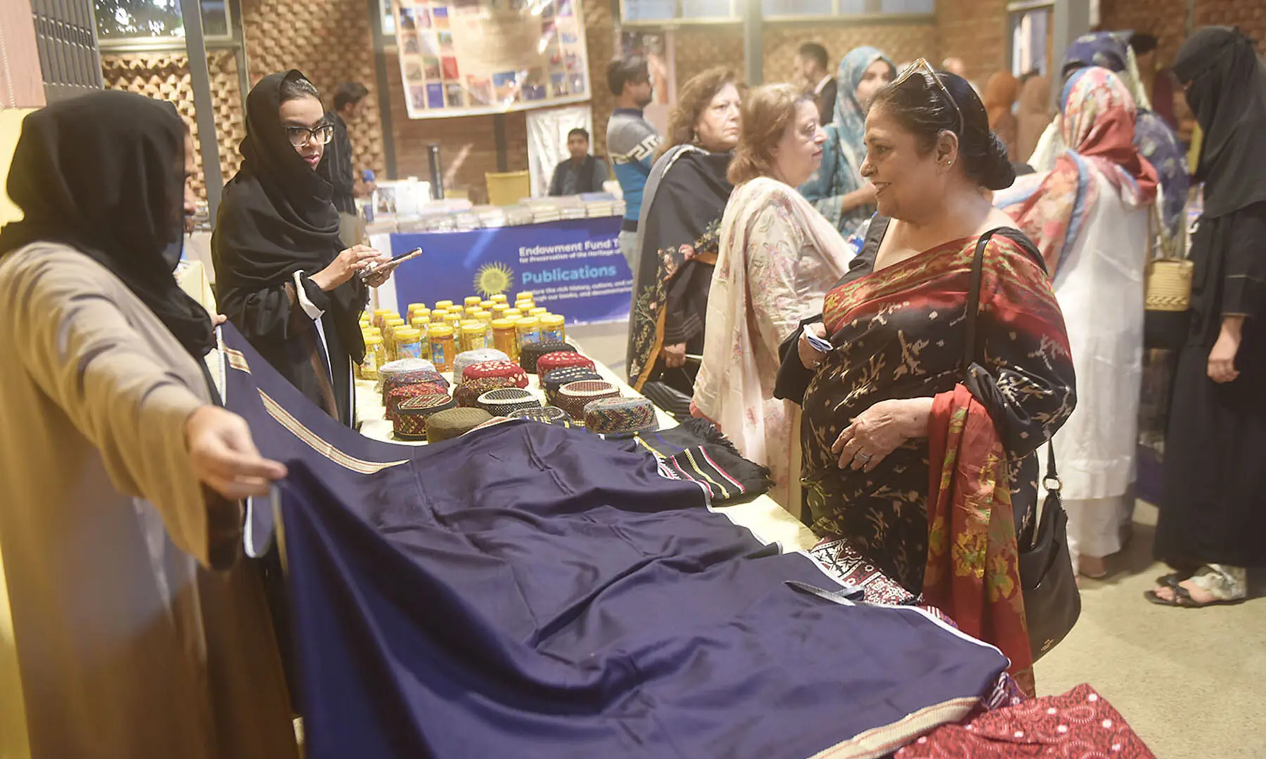 A visitor looks at fabrics being sold at the Adab Festival on November 22. — Fahim Siddiqui