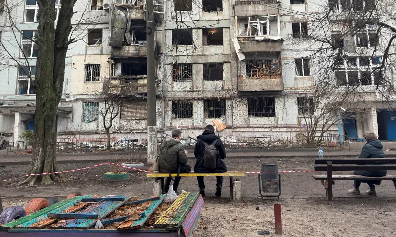 Residents sit near an apartment building damaged during a Russian drone strike, amid Russia’s attack on Ukraine, in Dnipro, Ukraine on Nov 23, 2025. — Reuters