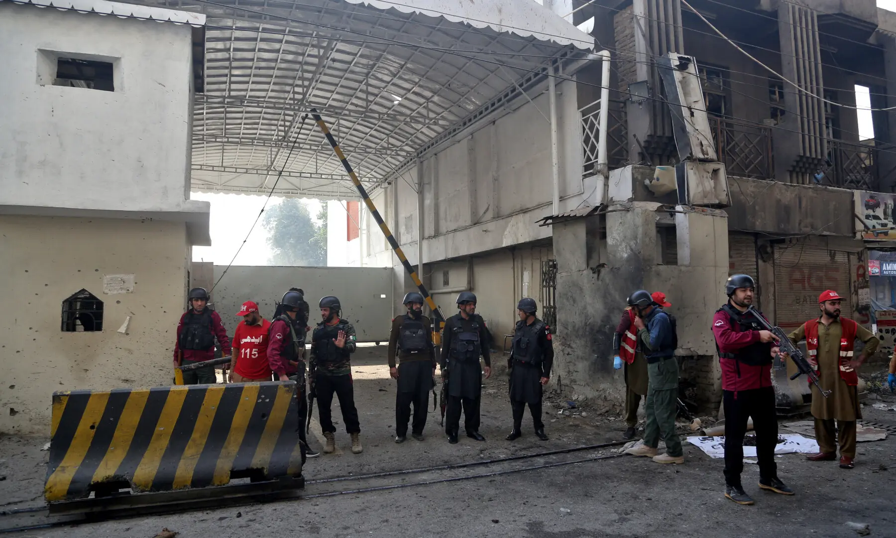 Paramilitary soldiers stand guard at the site after suicide bombers targeted the Federal Constabulary headquarters in Peshawar on November 24. — Reuters