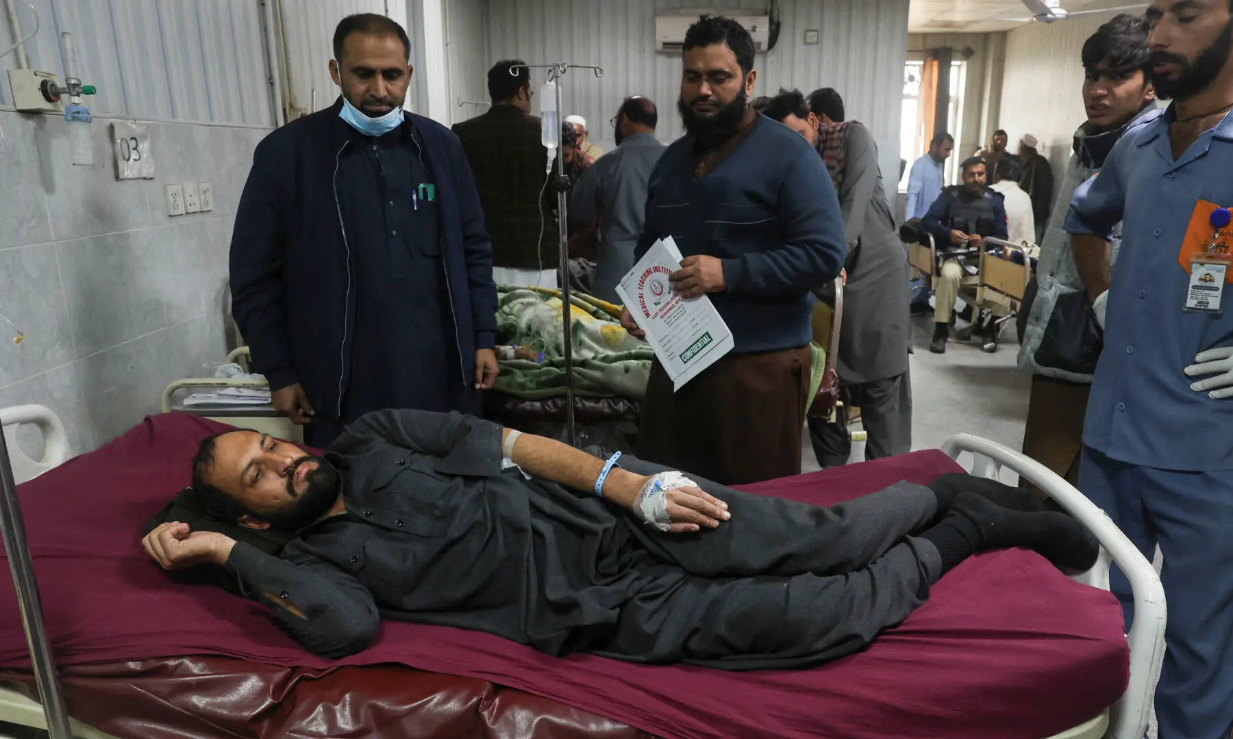 A man, who was injured after suicide bombers targeted the Federal Constabulary headquarters receives medical aid at a hospital, in Peshawar on November 24. — Reuters