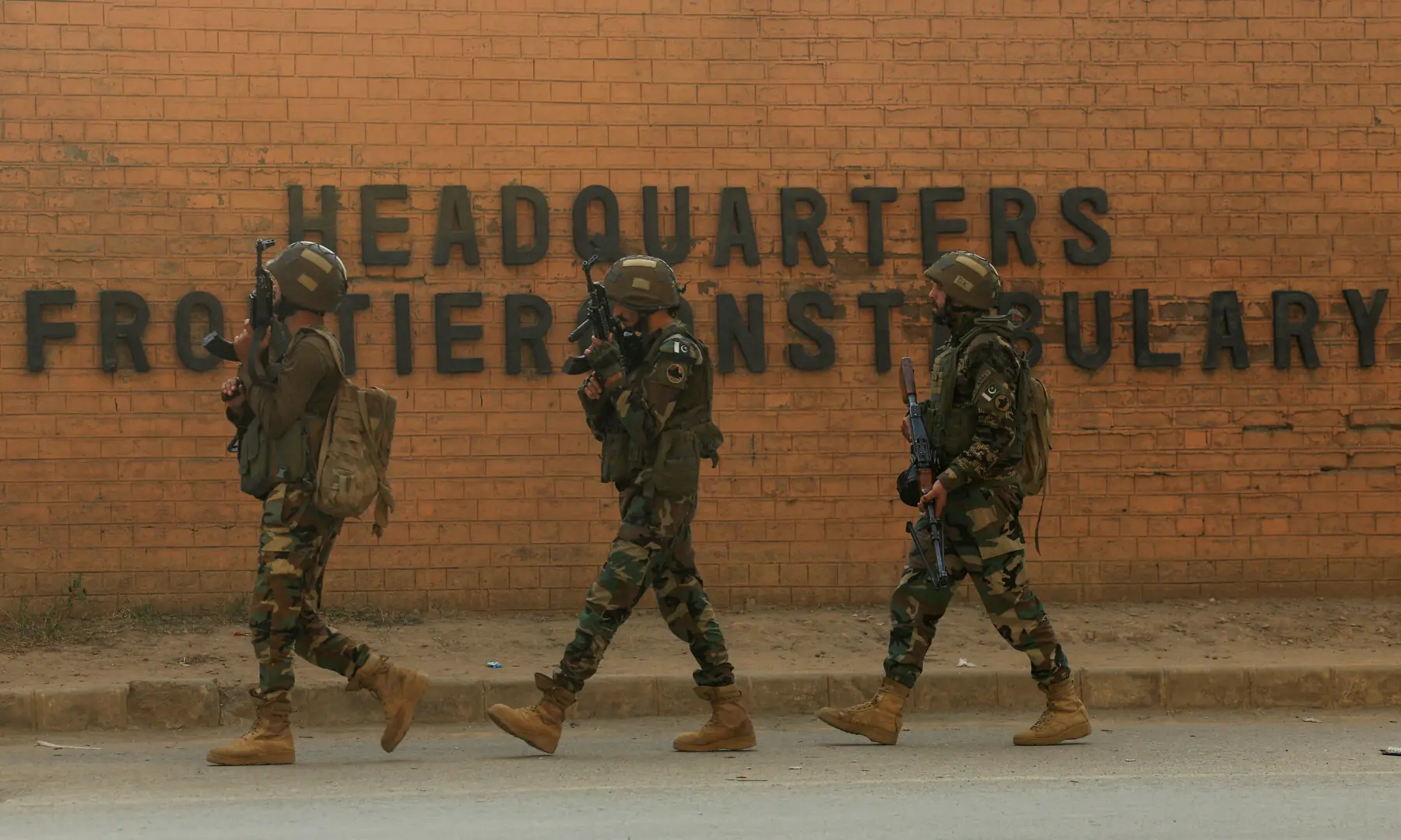 Army soldiers walk, after suicide bombers targeted the headquarters of the Federal Constabulary in Peshawar on November 24. — Reuters