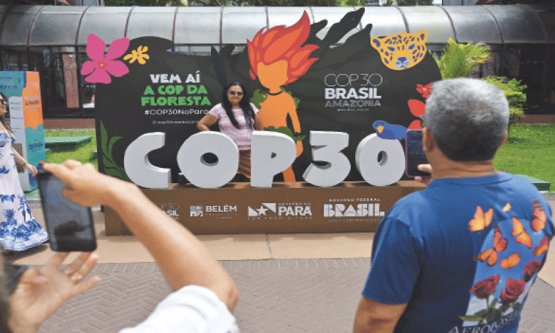 A visitor poses for a picture with the COP30 mascot, inside the Estacao das Docas, a tourist port area in Belem, Para State, Brazil.&mdash;AFP