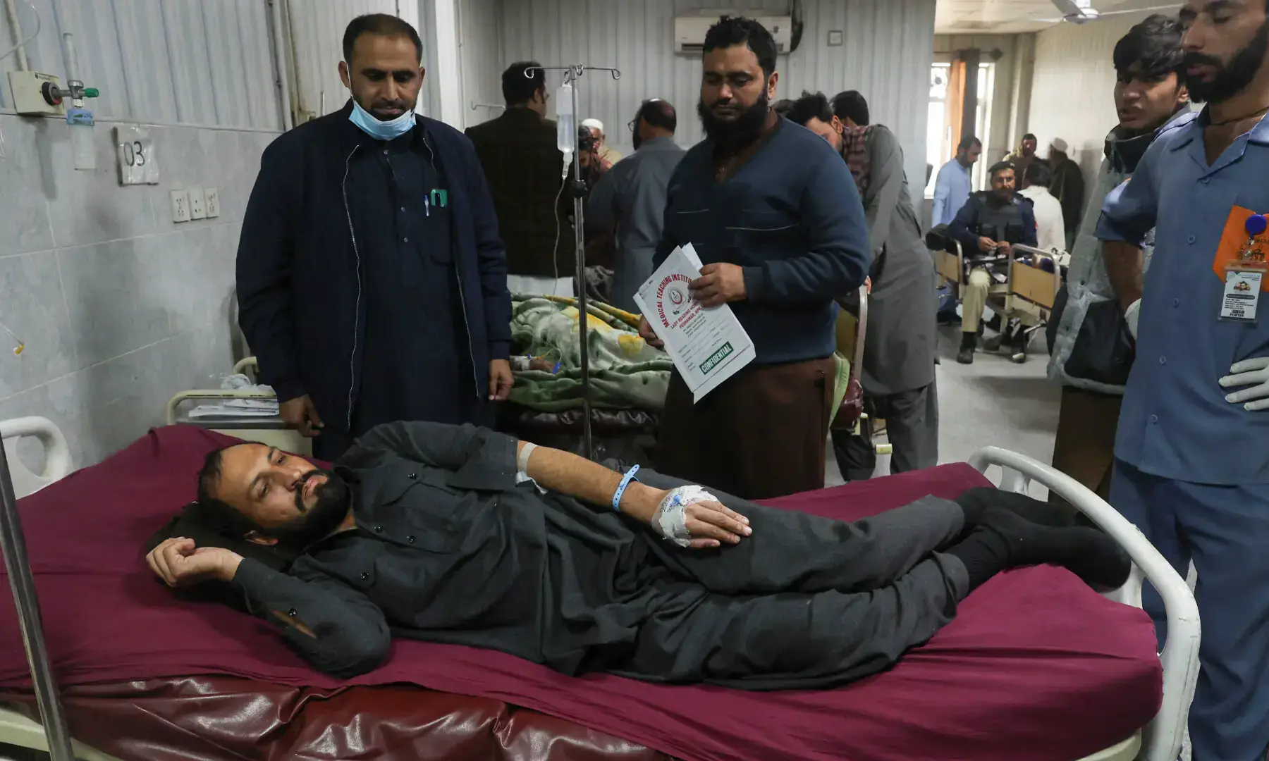 A man, who was injured after suicide bombers targeted the headquarters of the Federal Constabulary, receives medical aid at a hospital, in Peshawar on November 24. &mdash; Reuters