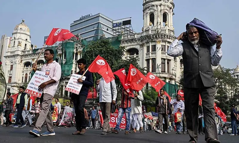 Trade Union members of the Communist Party of India walk with party flags during a protest against the government&rsquo;s new labour laws in Kolkata on November 26, 2025. Thousands of trade union workers across India protested on November 26, against the government&rsquo;s rollout of new labour codes, saying they would lead to corporate exploitation and erode their hard-won rights. (Photo by Dibyangshu SARKAR / AFP)