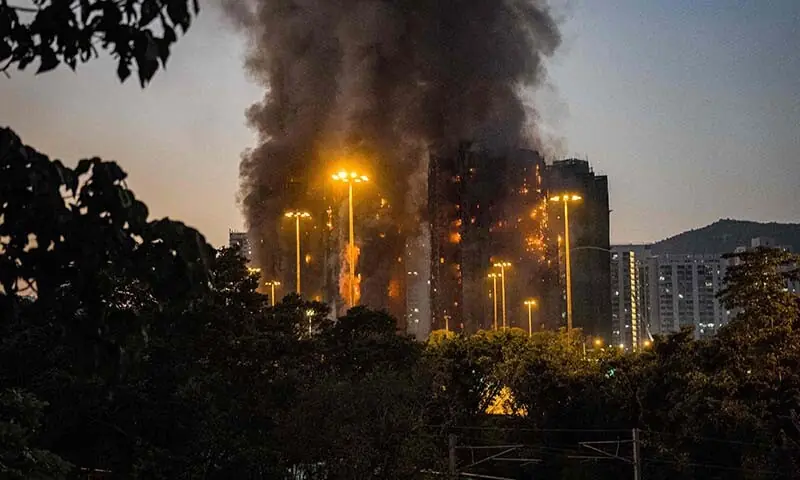 Thick smoke and flames rise as a major fire engulfs several apartment blocks at the Wang Fuk Court residential estate in Hong Kong’s Tai Po district on November 26, 2025. At least four people were killed when a fire engulfed several high-rise blocks in a Hong Kong residential estate on November 26, the government said, with media reporting that some residents were trapped inside. (Photo by AFP)