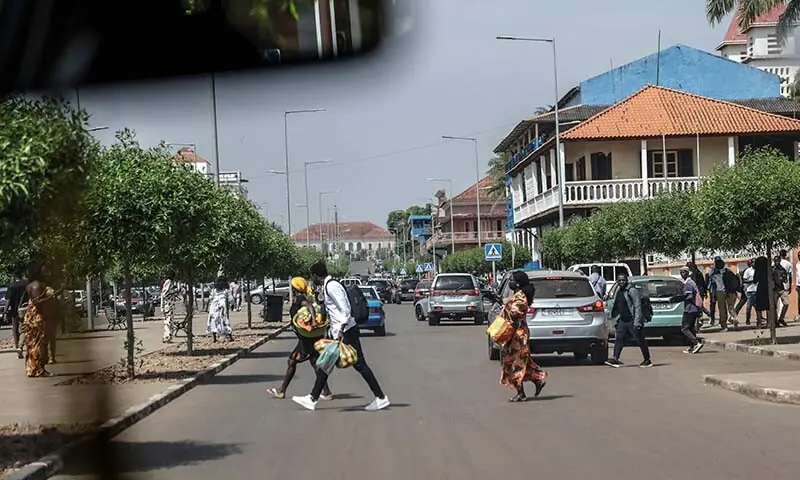 People flee the scene as gunfire rings out near the Presidential Palace in Bissau, Guinea-Bissau on November 26. &mdash; AFP