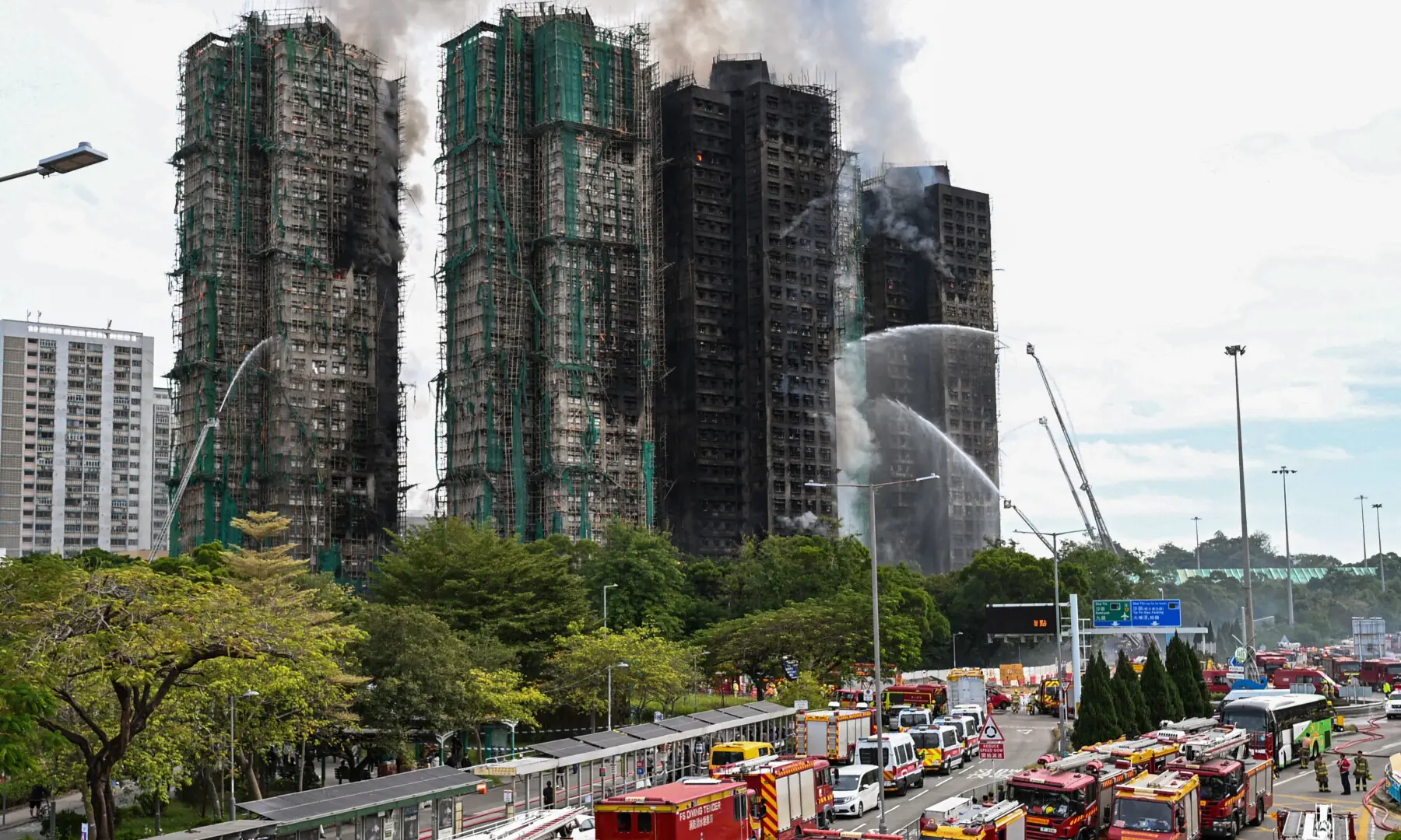 Firefighters spray water on flames as a large fire rages through several apartment blocks in the Wang Fuk Court housing estate in Hong Kong's Tai Po district on November 27, 2025. — AFP