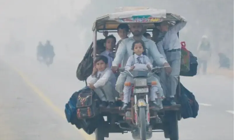 Schoolchildren on way to school on a motorcycle-rickshaw during smoggy weather. &mdash; Online